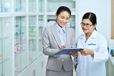 woman showing documents to female pharmacist