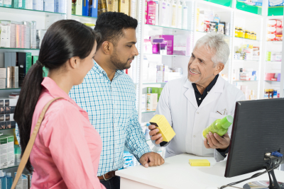 pharmacist dealing medical products to two people